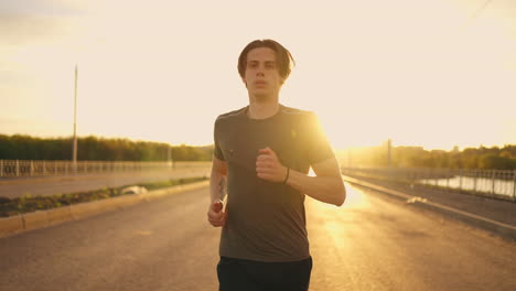 endurance-and-speed-of-sporty-man-running-on-road-in-sunny-morning-medium-portrait